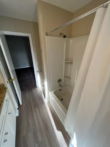 a bathroom with a tub a sink and glass door shower