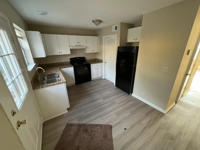 a kitchen with a refrigerator sink and cabinets