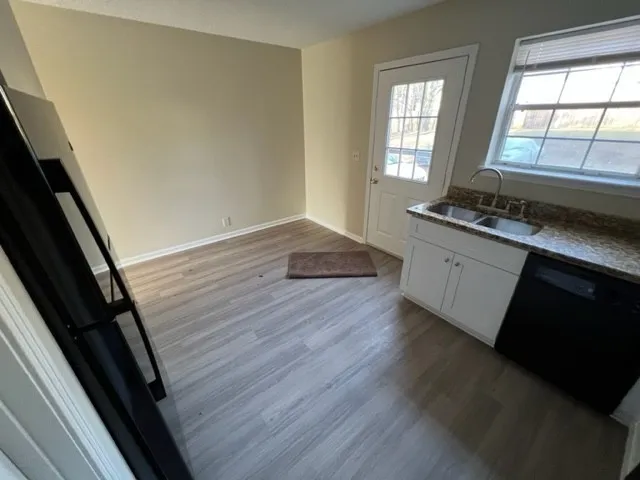 a kitchen with granite countertop a stove and wooden floor