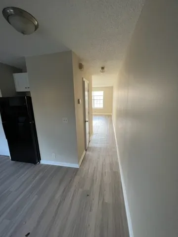 a view of a hallway with wooden floor