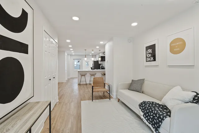 a living room with furniture and a wooden floor