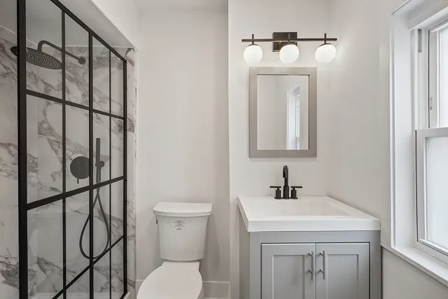 a bathroom with a sink a toilet and mirror