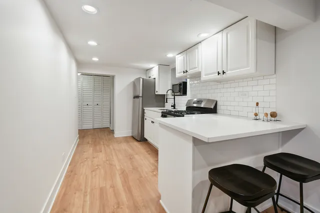 a kitchen with a sink a refrigerator and cabinets