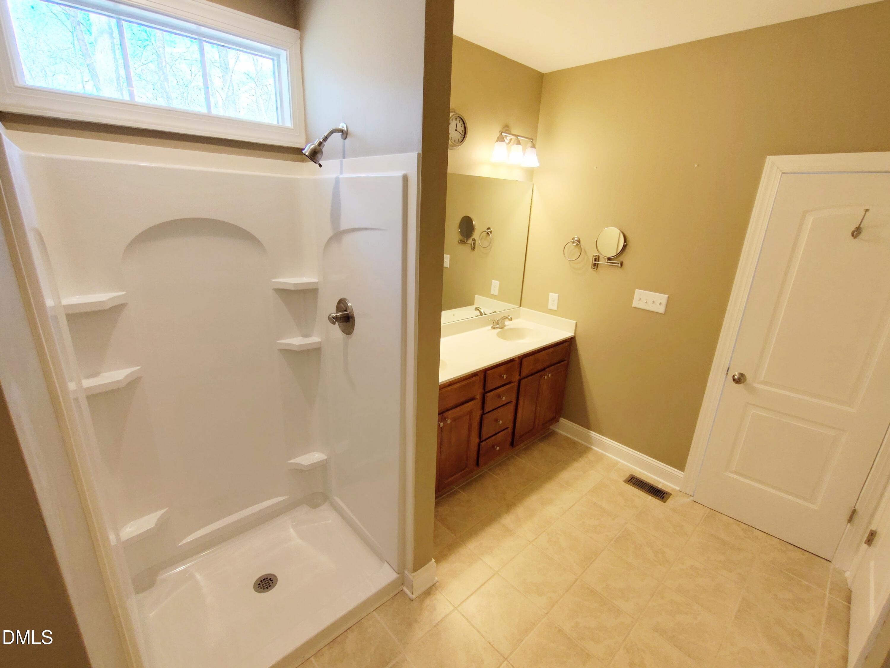 279 Weaver Ridge Road Rougemont, NC 27572 - Photo 16 of 25 a bathroom with a tub shower vanity and a sink