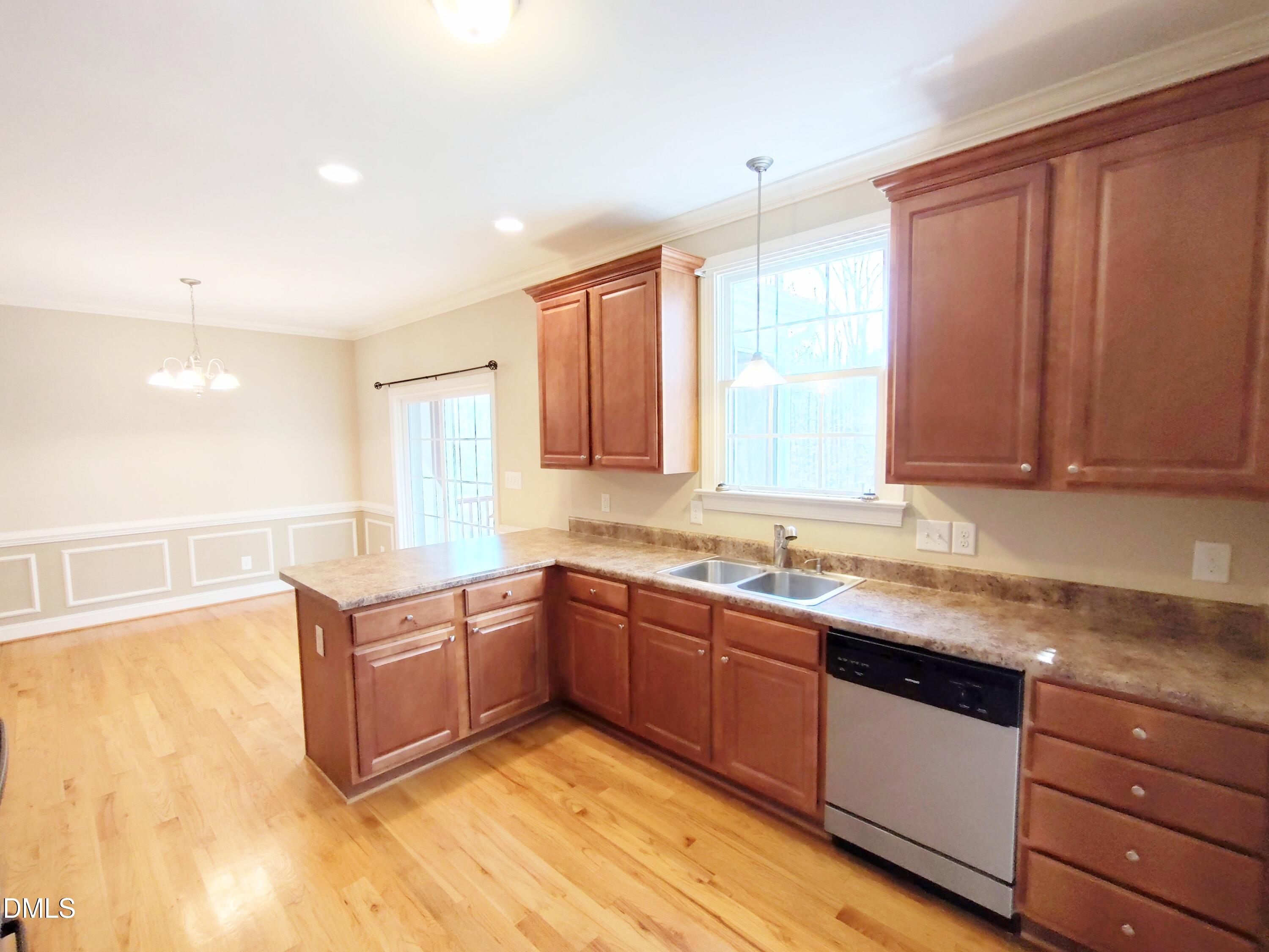 279 Weaver Ridge Road Rougemont, NC 27572 - Photo 9 of 25 a kitchen with stainless steel appliances granite countertop wooden cabinets a sink and dishwasher with wooden floor