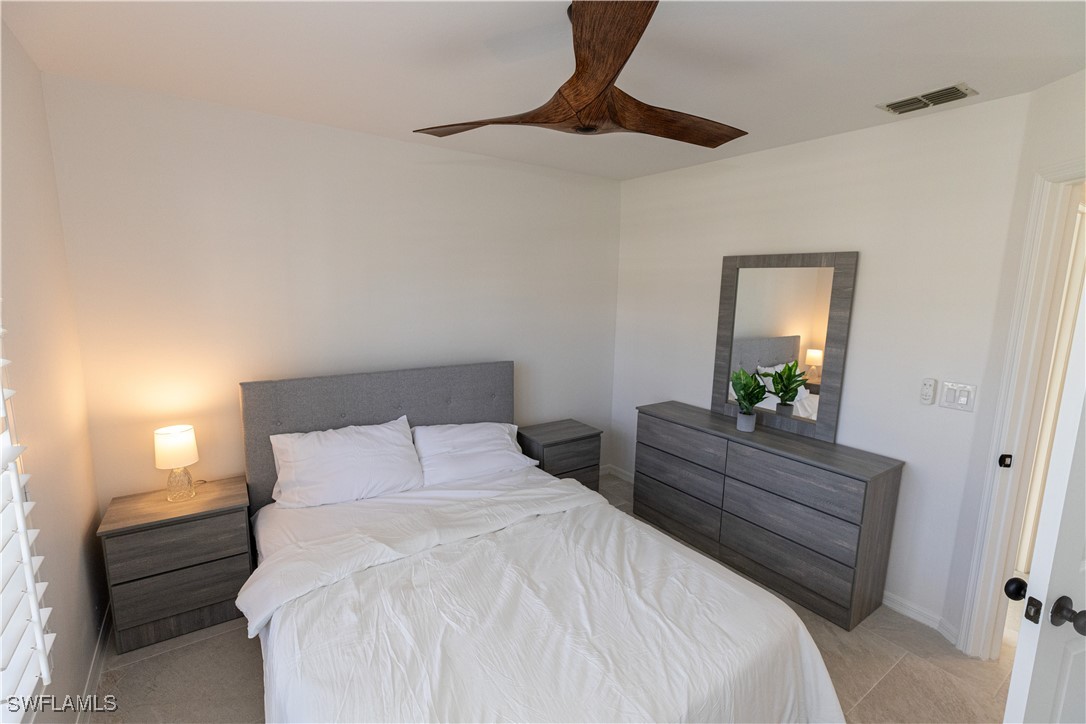 2170 Faliron Road North Fort Myers, FL 33917 - Photo 16 of 30 a bedroom with a bed and a chandelier