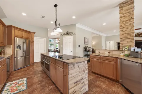 a kitchen with stainless steel appliances granite countertop a sink a stove and a refrigerator