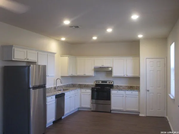 a kitchen with a refrigerator and a stove top oven