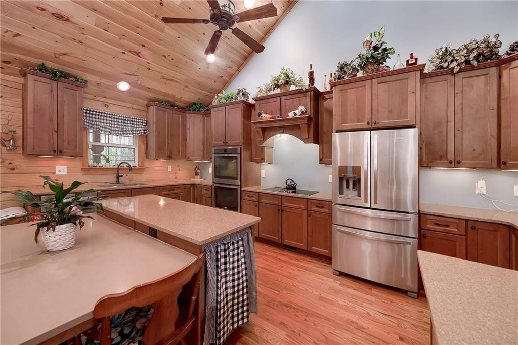 570 Eskew Road McDonough, GA 30252 - Photo 28 of 89 a kitchen with stainless steel appliances a refrigerator a sink a stove and white cabinets with wooden floor