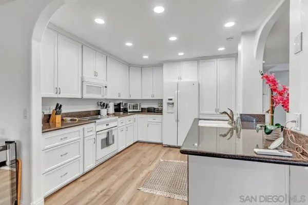a kitchen with kitchen island granite countertop a sink cabinets and stainless steel appliances