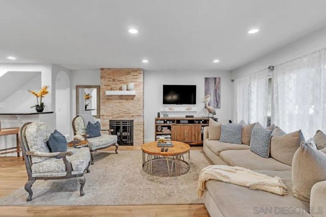 a living room with furniture a fireplace and a flat screen tv