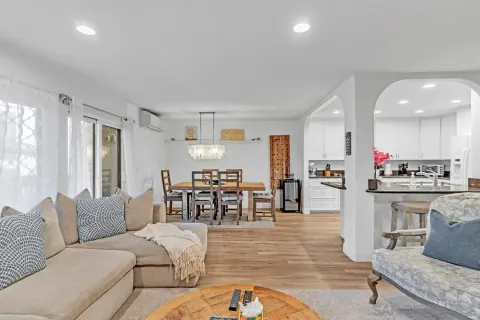 a living room with furniture kitchen view and a large window