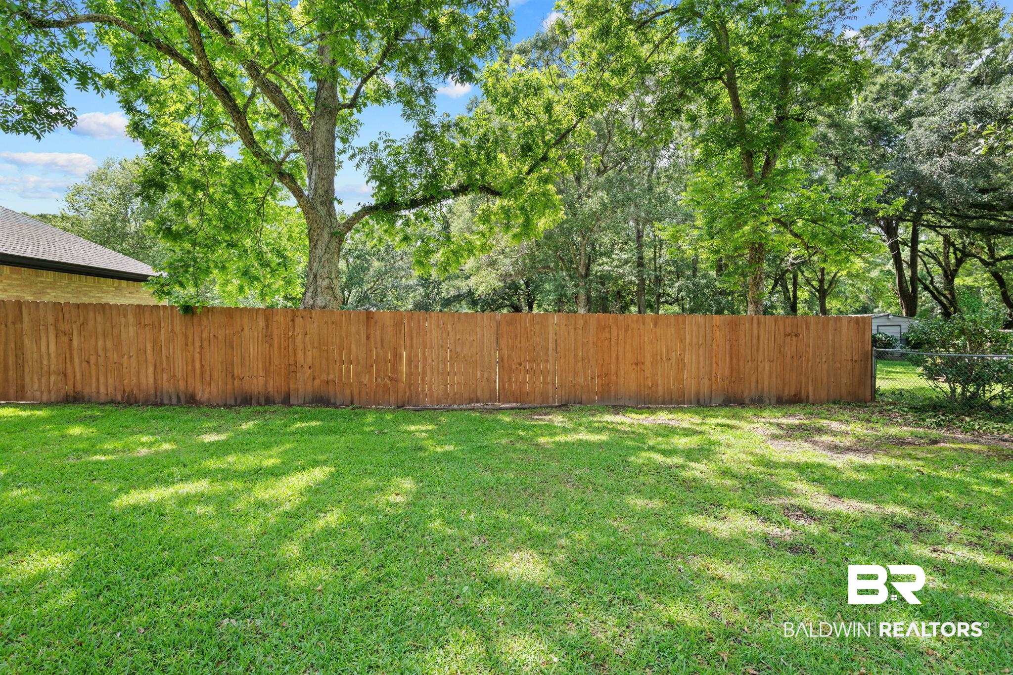 5936 Lundy Road Theodore, AL 36582 - Photo 28 of 32 Expansive grassy area featuring a wood privacy fence and mature trees