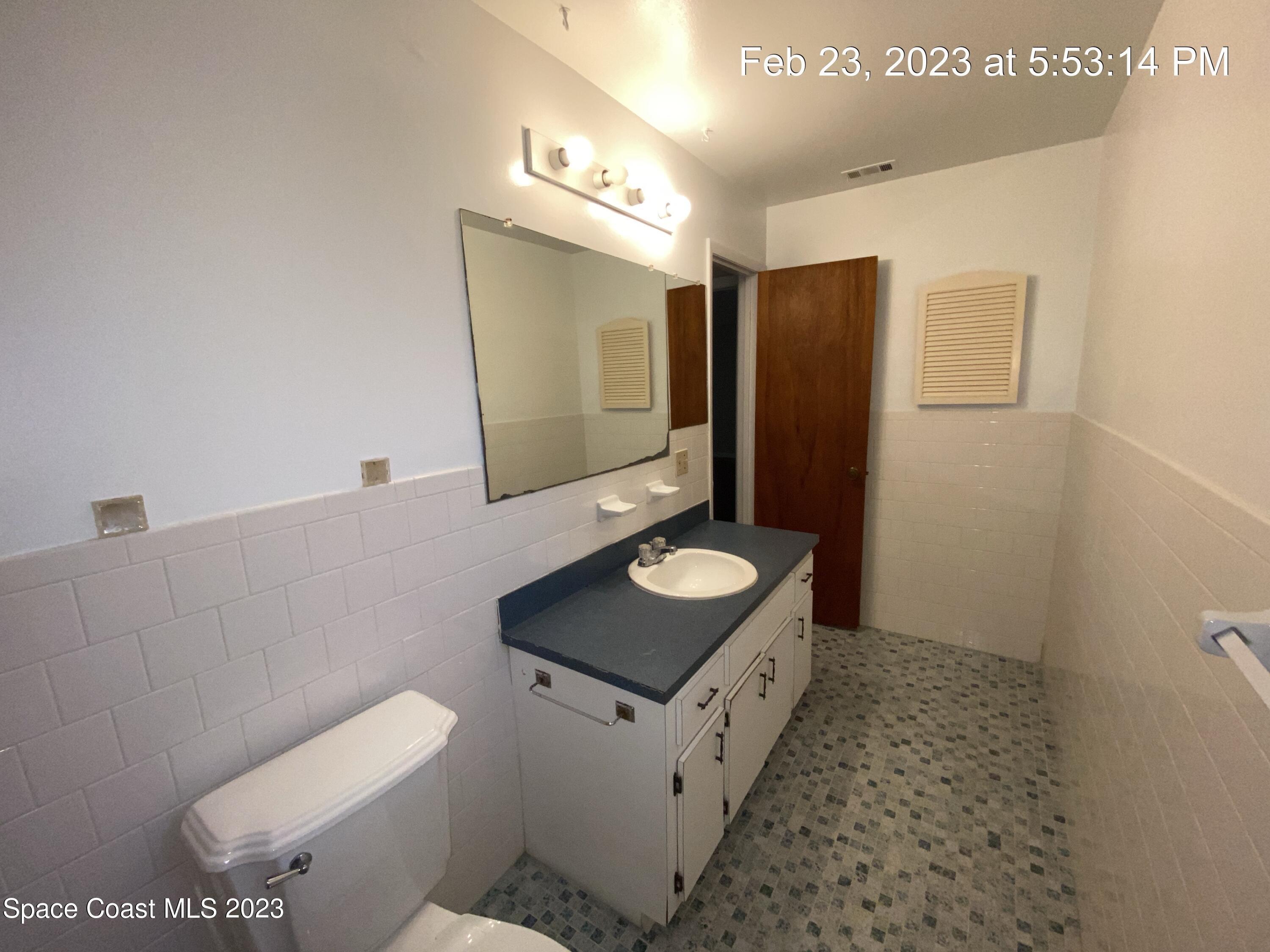 304 Darrow Avenue Melbourne, FL 32901 - Photo 26 of 31 a bathroom with a toilet sink and mirror