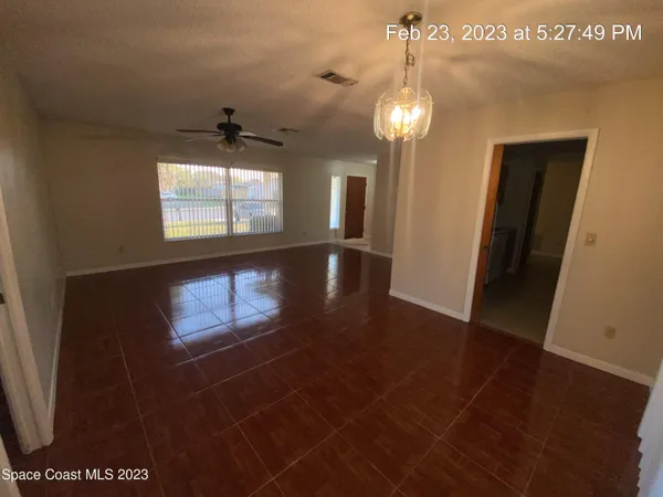 a view of a room with a window and wooden floor