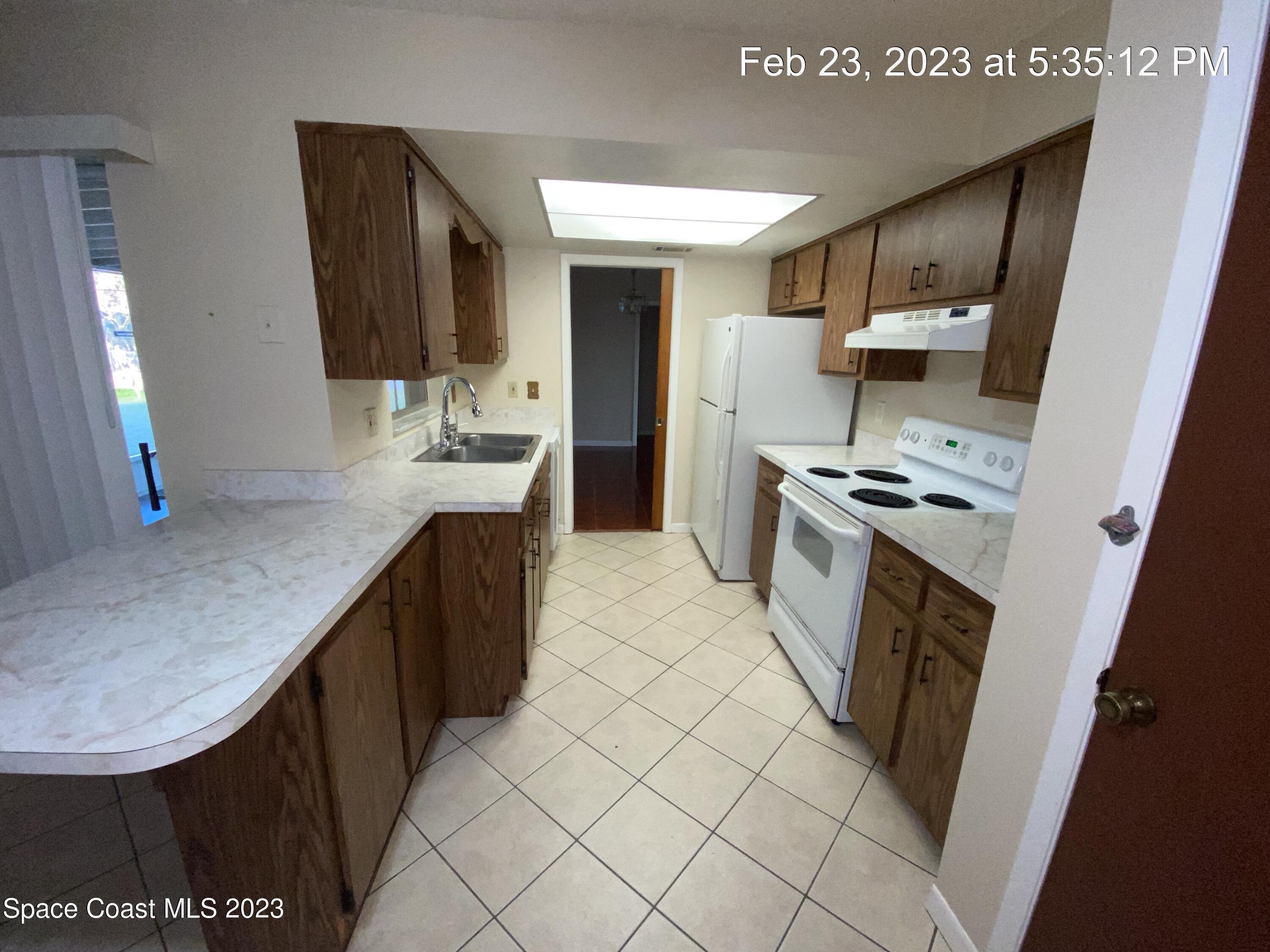 304 Darrow Avenue Melbourne, FL 32901 - Photo 7 of 31 a kitchen with kitchen island a sink stove and refrigerator