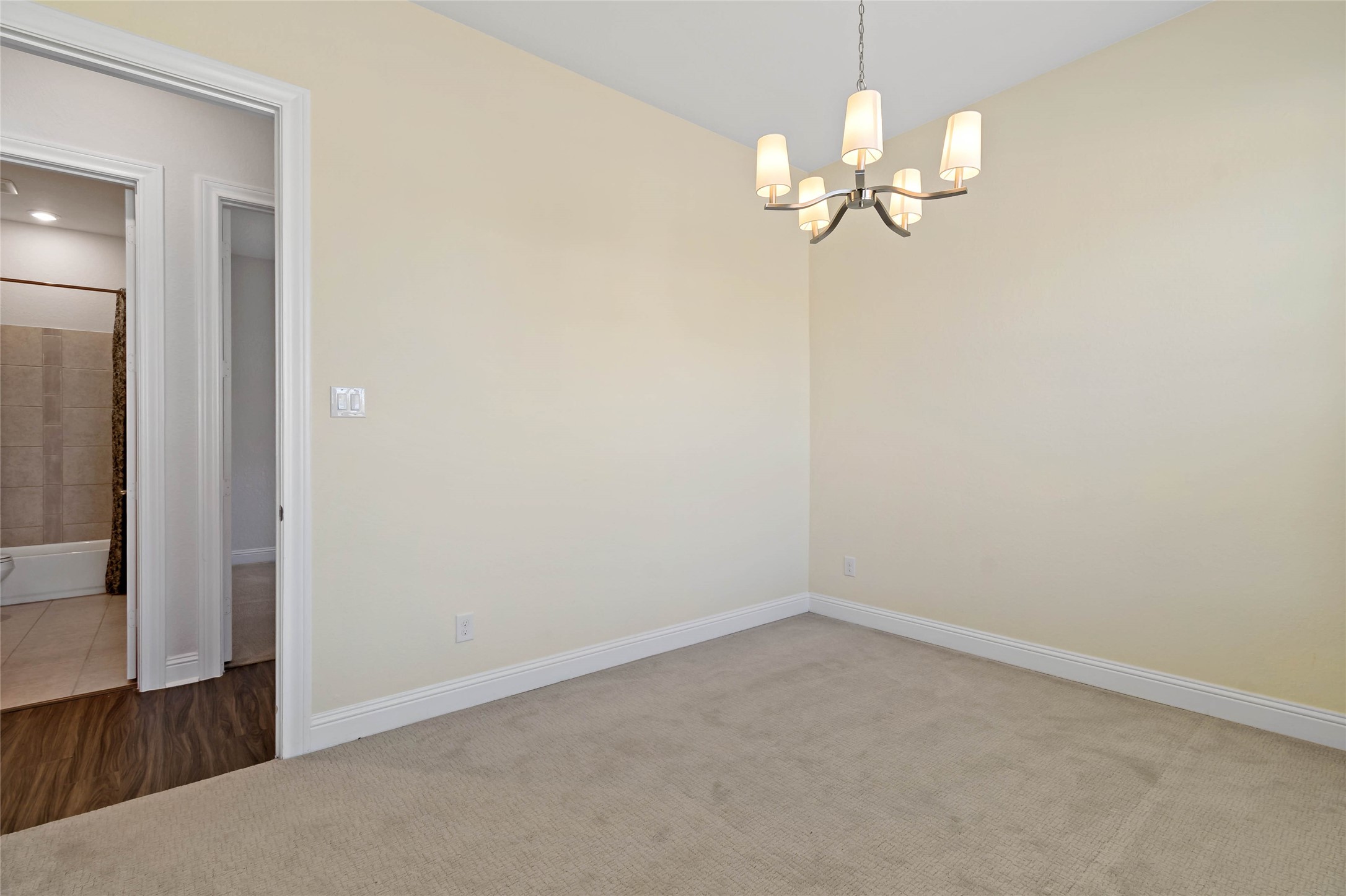 4802 Gingerwood Trace Lane Rosharon, TX 77583 - Photo 5 of 44 an empty room with a chandelier fan and wooden floor