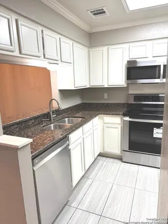 a kitchen with stainless steel appliances granite countertop a sink stove and cabinets