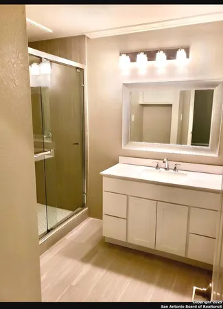 a bathroom with a double vanity sink mirror and shower