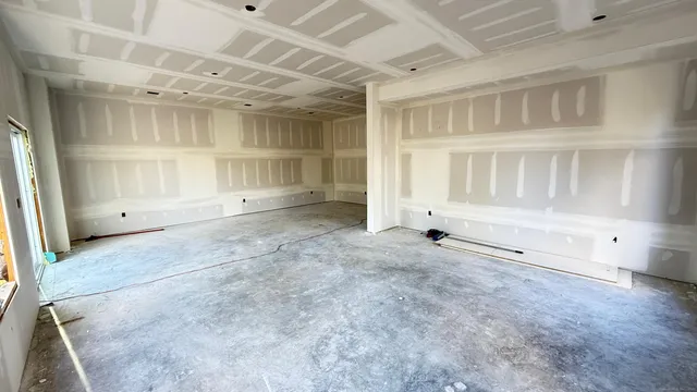 an empty room with wooden cabinet and windows