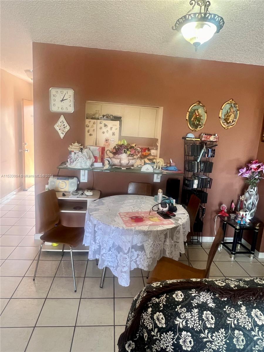 1075 West 68th Street, Unit 309 Hialeah, FL 33014 - Photo 13 of 21 a living room with furniture and a table