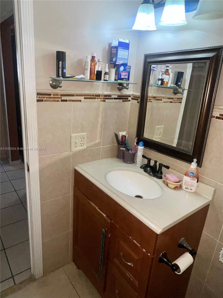 1075 West 68th Street, Unit 309 Hialeah, FL 33014 - Photo 16 of 21 a bathroom with a sink vanity and mirror