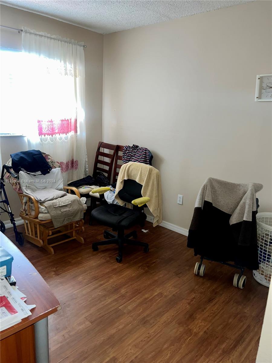 1075 West 68th Street, Unit 309 Hialeah, FL 33014 - Photo 18 of 21 a living room with furniture and wooden floor