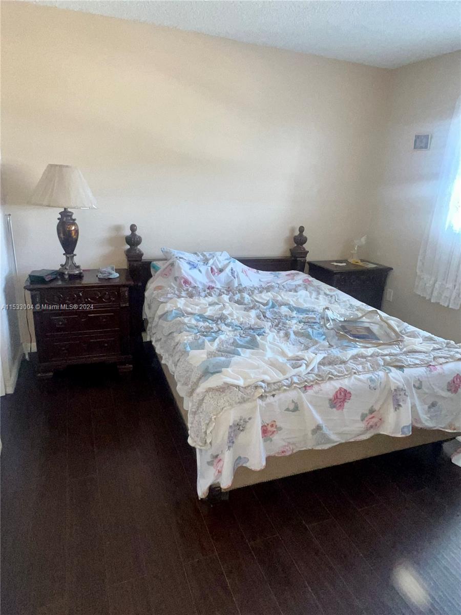 1075 West 68th Street, Unit 309 Hialeah, FL 33014 - Photo 19 of 21 a bed sitting in a bedroom next to a lamp