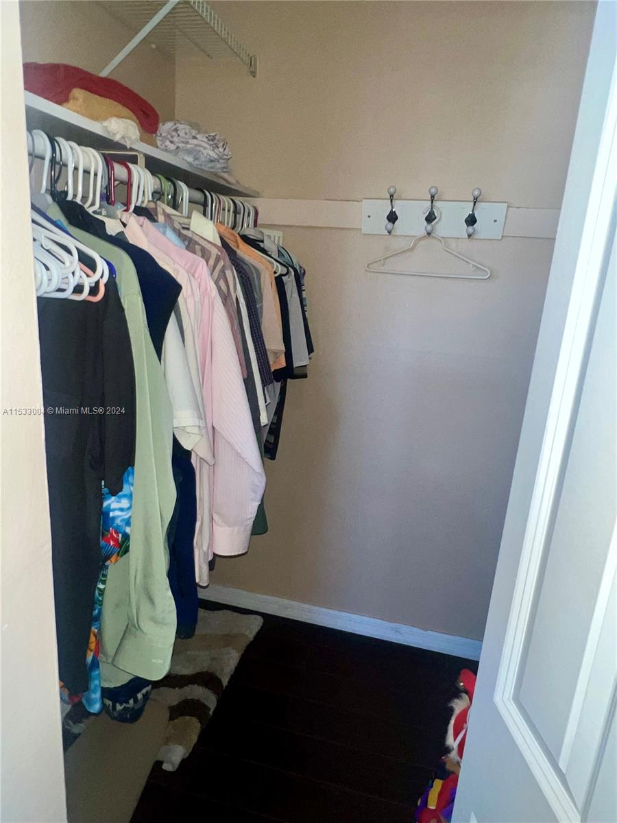 1075 West 68th Street, Unit 309 Hialeah, FL 33014 - Photo 21 of 21 a view of walk in closet with clothes and shoes