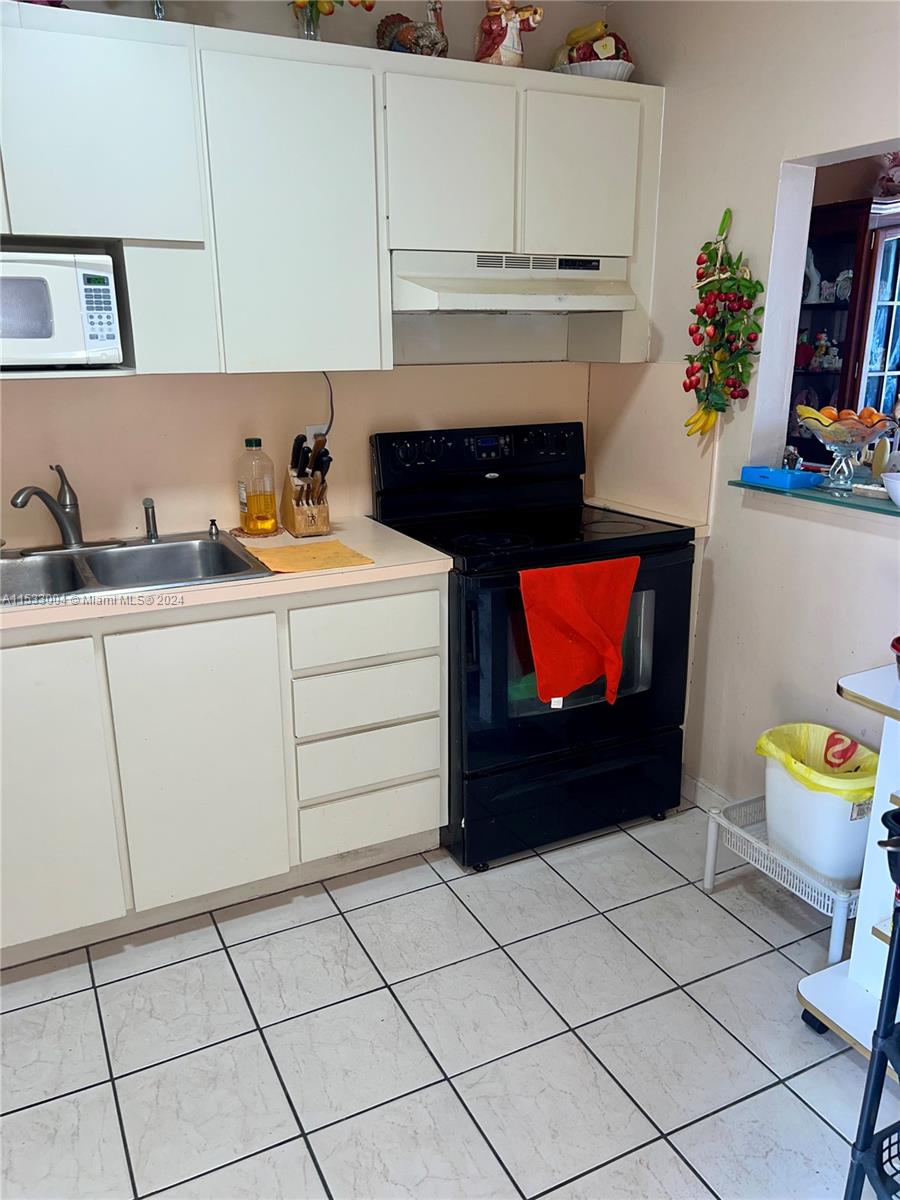 1075 West 68th Street, Unit 309 Hialeah, FL 33014 - Photo 5 of 21 a kitchen with a cabinets and a fireplace