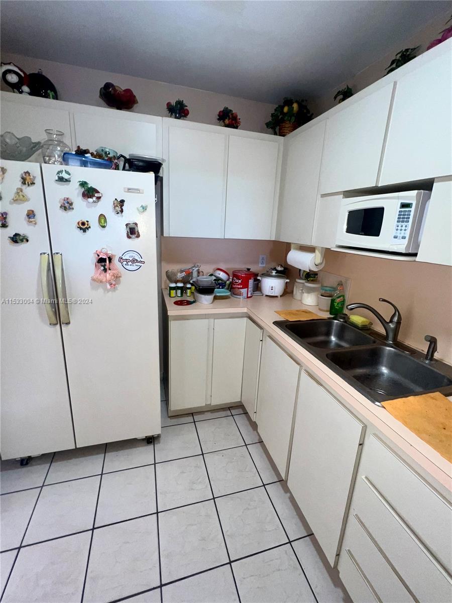 1075 West 68th Street, Unit 309 Hialeah, FL 33014 - Photo 6 of 21 a kitchen with stainless steel appliances a stove a refrigerator and a sink