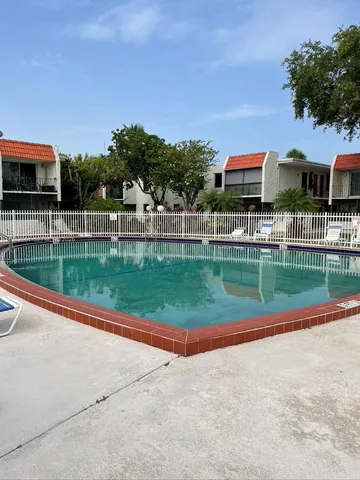 a view of a house with a swimming pool and a yard