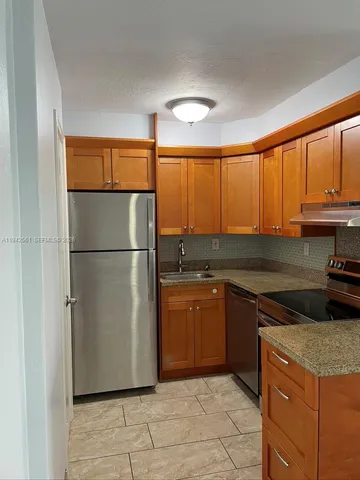 a kitchen with stainless steel appliances granite countertop a refrigerator and a sink