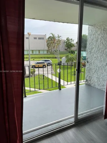 a view of a porch with a floor to ceiling window next to a yard