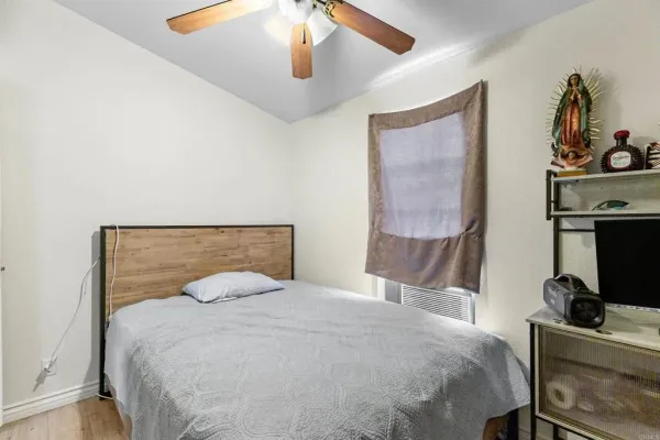 a bedroom with a bed and a lamp on the dresser