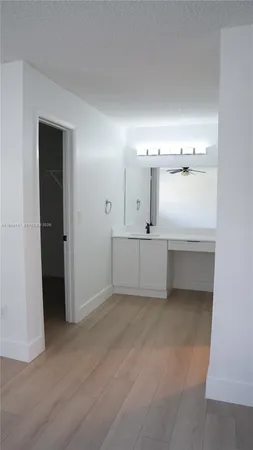 an empty room with a window and a ceiling fan