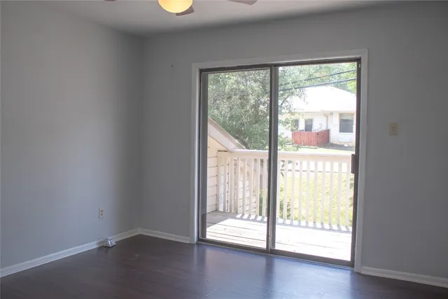 a view of an empty room and wooden floor and windows