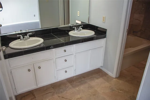 a bathroom with double sink and a mirror
