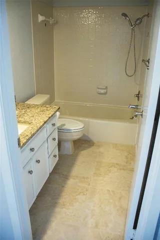a bathroom with a granite countertop sink a toilet and shower