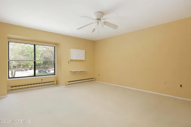 an empty room with a window and a ceiling fan