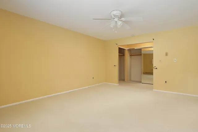 an empty room with a ceiling fan and a window