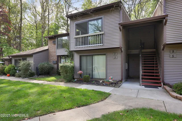 a view of a house with a yard and plants with large tree