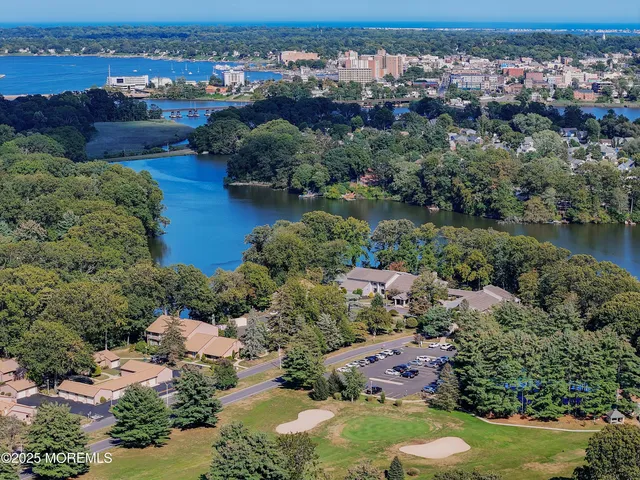 an aerial view of a houses with a yard and lake view