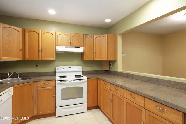 a kitchen with granite countertop cabinets stainless steel appliances and a sink