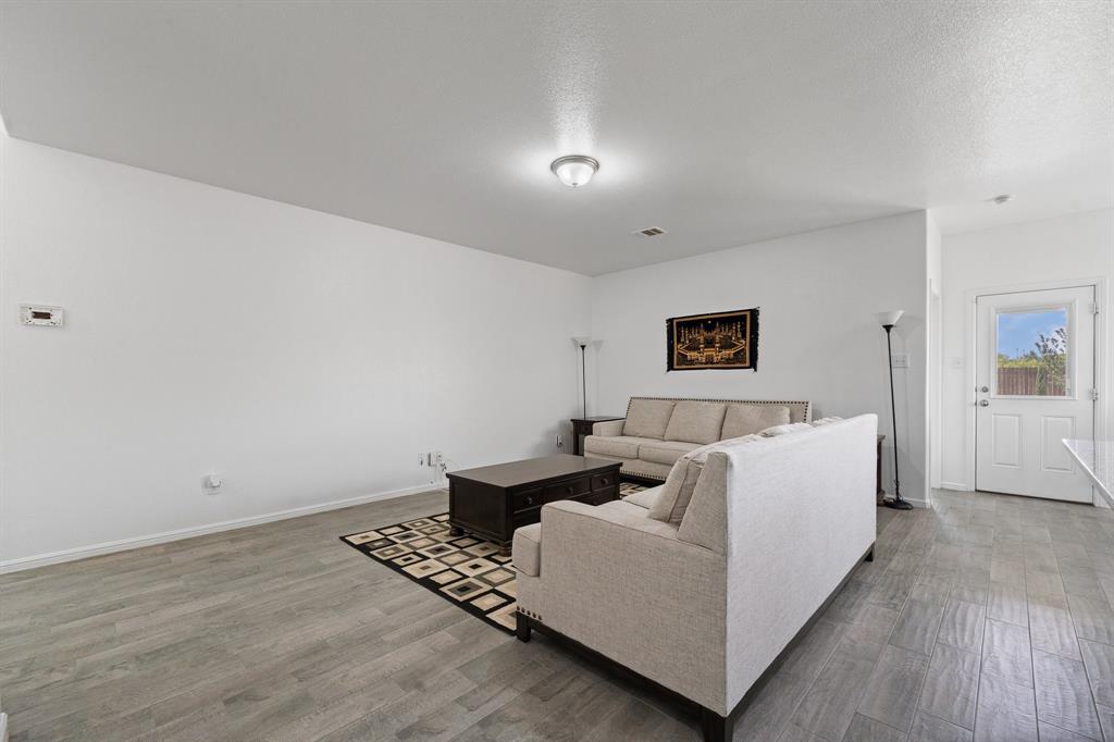 4600 Fringetree Way Crowley, TX 76036 - Photo 18 of 40 Spacious room featuring wood-finish flooring, recessed lighting, and a white paneled door with window