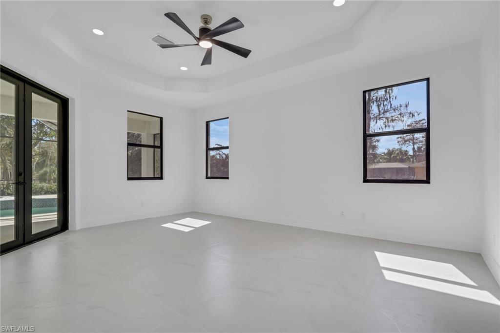 730 29th Street Southwest Naples, FL 34117 - Photo 26 of 50 Empty room with a ceiling fan, a tray ceiling, recessed lighting, and finished concrete flooring