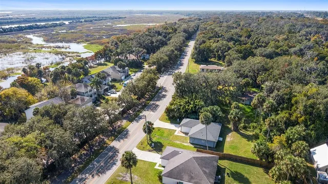 an aerial view of residential house with outdoor space and trees all around