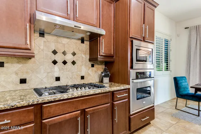 a kitchen with kitchen island granite countertop a sink a counter top space appliances and a window