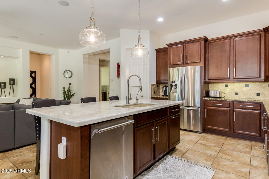 4647 North Aldea Road East Litchfield Park, AZ 85340 - Photo 18 of 49 a kitchen with kitchen island granite countertop a sink stove and refrigerator