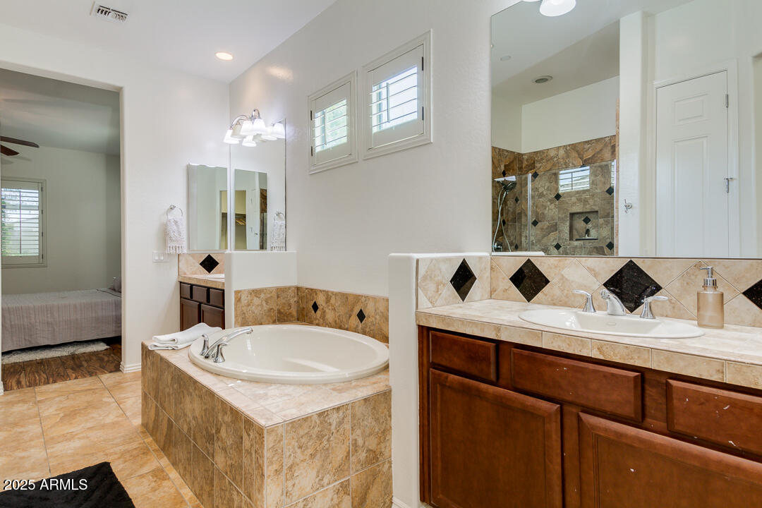 4647 North Aldea Road East Litchfield Park, AZ 85340 - Photo 28 of 49 a bathroom with a tub sink and mirror